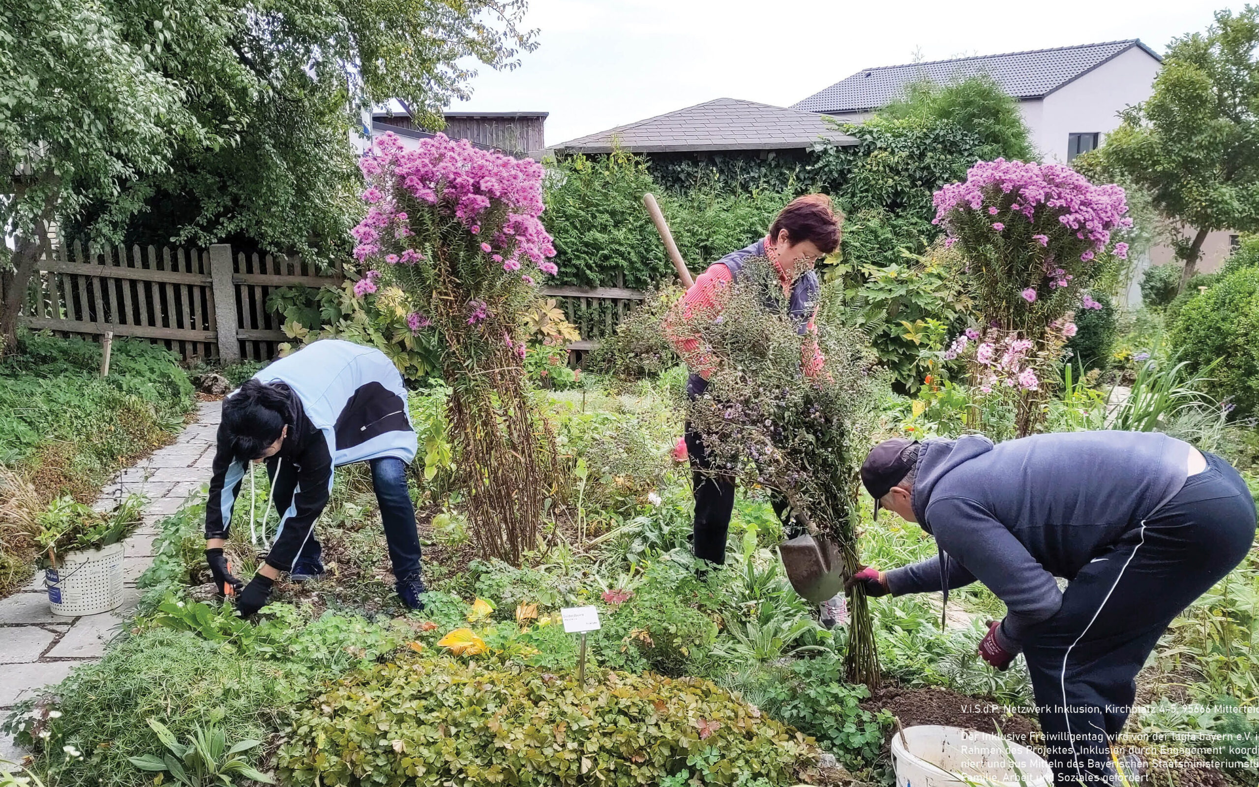 Drei Personen, 2 Frauen und ein Mann, stehen in einem Garten und machen Gartenarbeit.